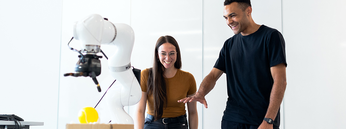 Millennial engineers in front of a robot